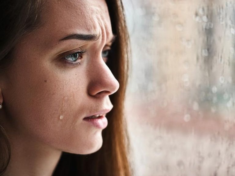 upset crying woman looking out the window