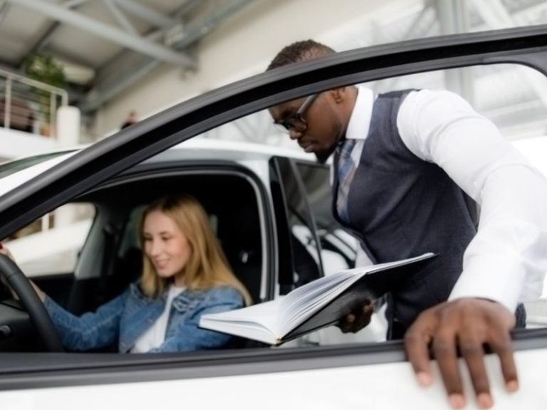 sales consultant shows car to woman